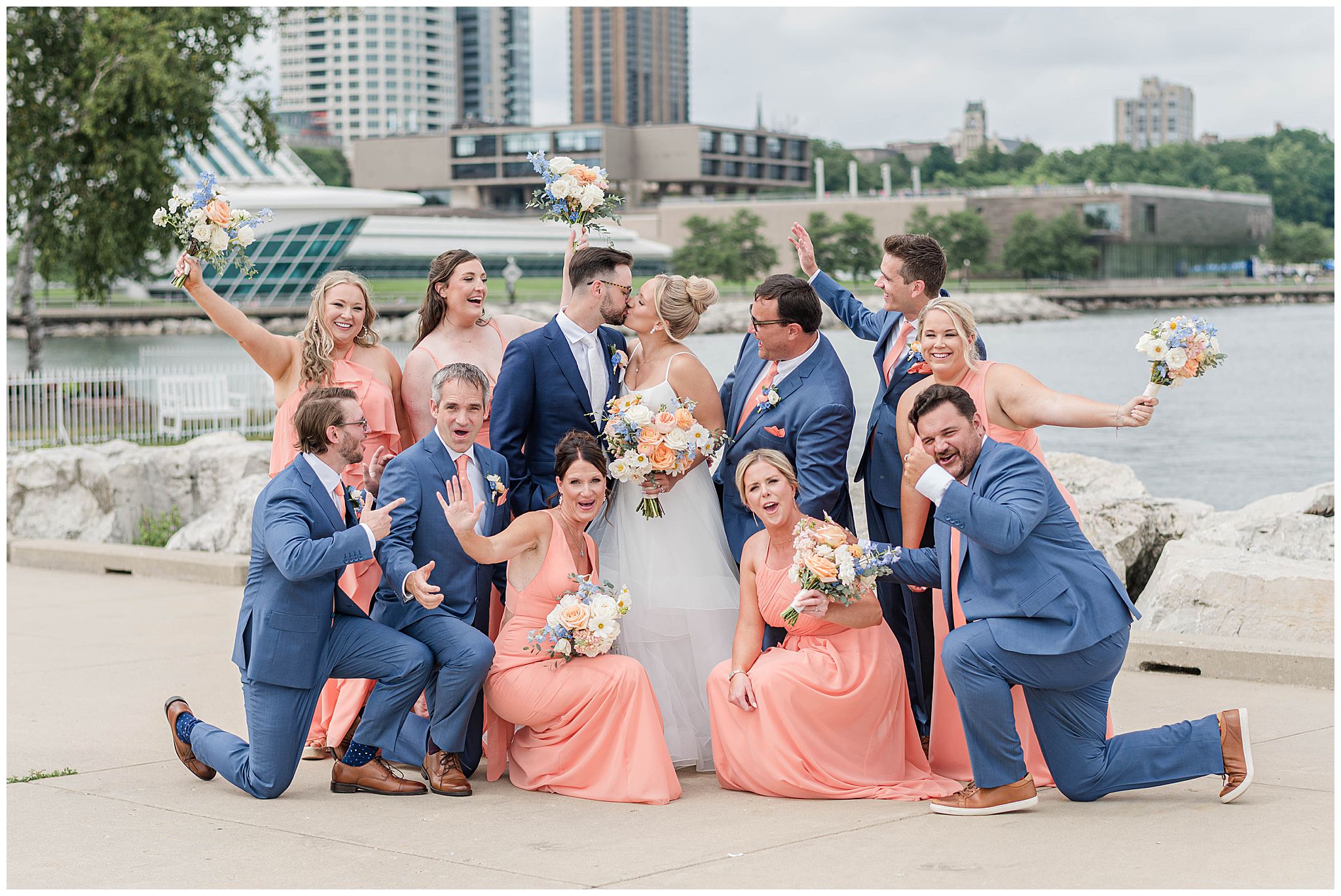 A wedding party cheers as they celebrate the bride and groom.