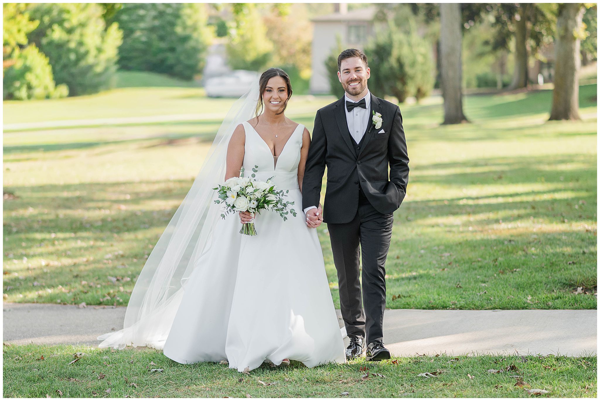 A classic bride and groom portrait as they walk along the water at The Abbey Resort in Lake Geneva, taken by a Lake Geneva wedding photographer.